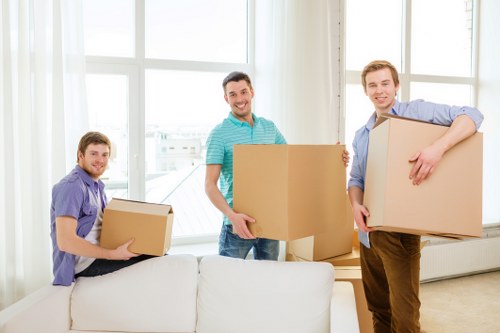 Professional movers handling boxes and furniture in a local flat